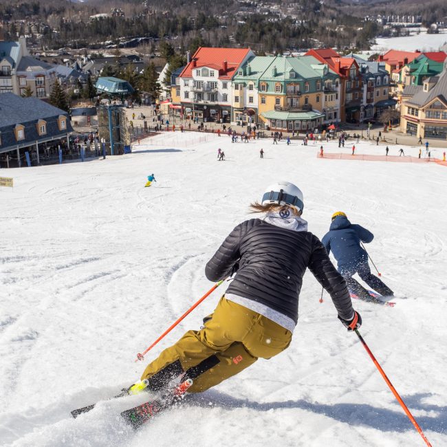 © Pierre-Alexandre Legault Skifahrer carven den Hang in Richtung Tremblant hinab