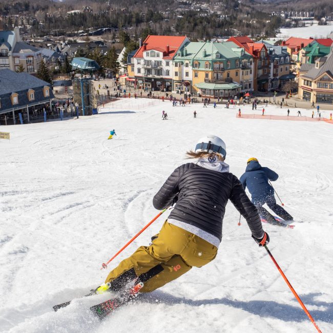 Skifahrer carven den Hang in Richtung Tremblant hinab